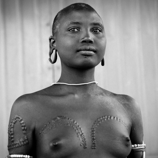 Mursi Topless Shaved Head Extended Earlobes And Scarified Woman Posing Omo Valley Ethiopia