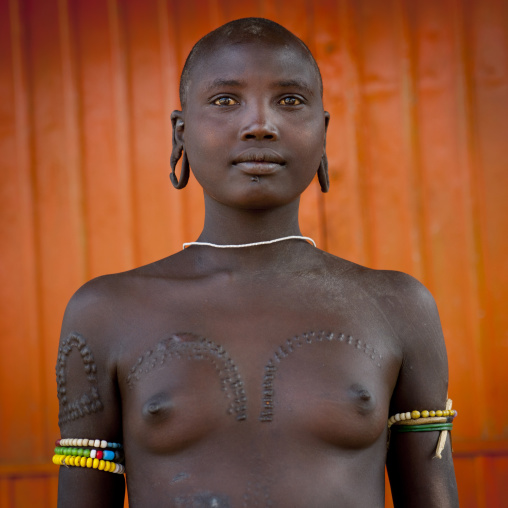 Mursi Topless Shaved Head Extended Earlobes And Scarified Woman Posing Omo Valley  Ethiopia