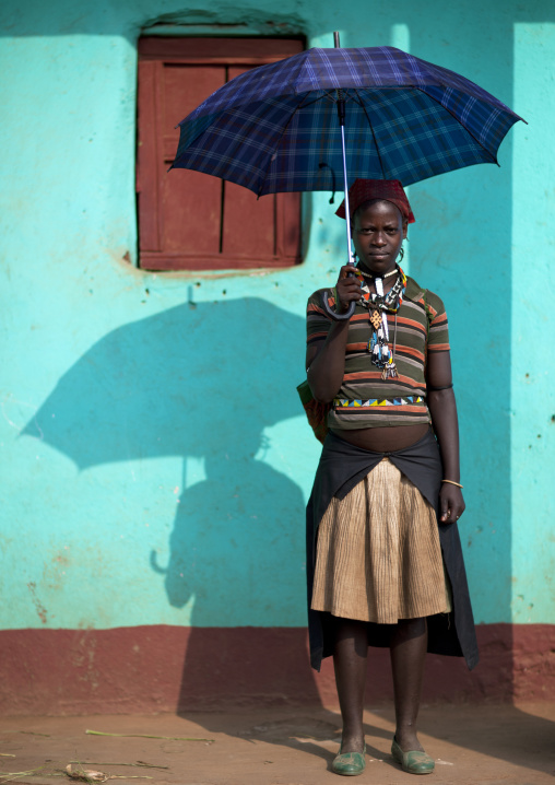 Traditional clothing ara woman posing outside of blue house in jinka omo valley Ethiopia