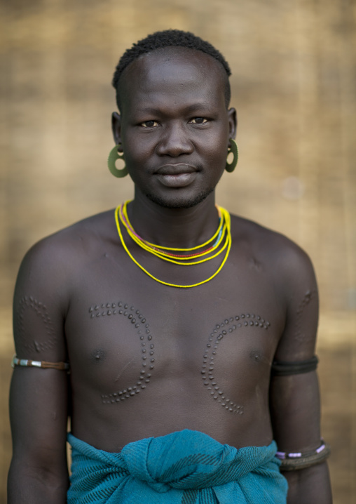 Mursi Man With Scarified Chest And Earrings Portrait Omo Valley Ethiopia
