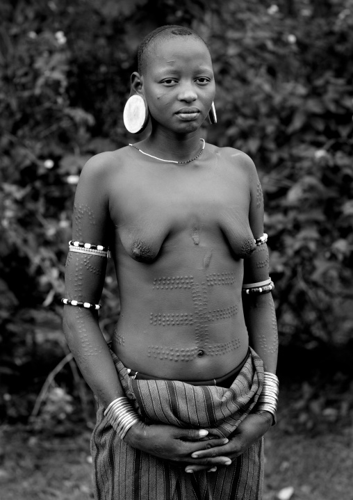 Portrait Of A Young Mursi Shaved Head Girl With Clay Plate In Ears In Jinka Omo Valley Ethiopia
