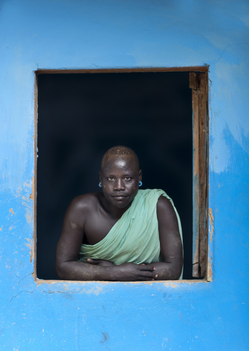 Bodi Man Looking At Camera  In The Frame Of A Blue Window Hana Mursi Village Omo Valley Ethiopia