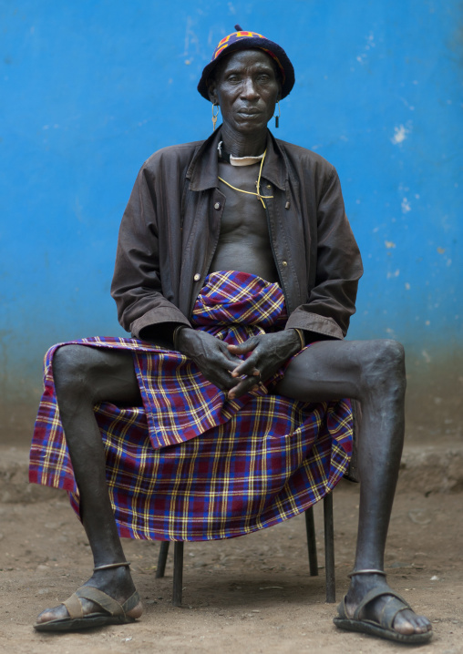 Senior Bodi Man Sitting On Chair With Opened Legs And Crossed Fingers Hana Mursi Village Omo Valley Ethiopia