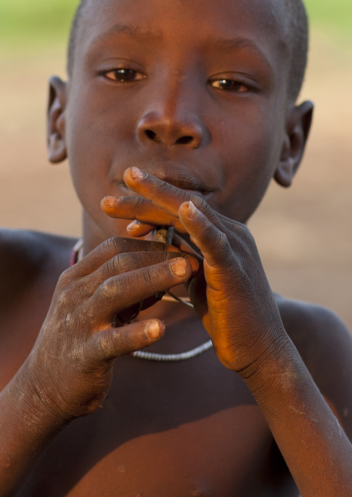 Young Boy Playing Flute With A Wooden Stick Ethiopia
