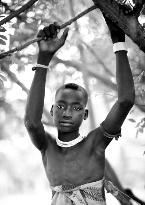 Bodi Teenage Boy Hanged Of A Branch Peaceful Look At Camera Omo Valley Ethiopia