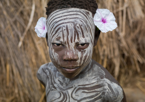 Mursi tribe boy wearing makeup and flowers, Omo valley, Mago National Park, Ethiopia