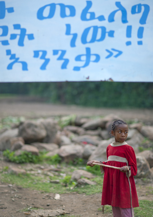 Young girl in front of giant ahmaric billboard Ethiopia