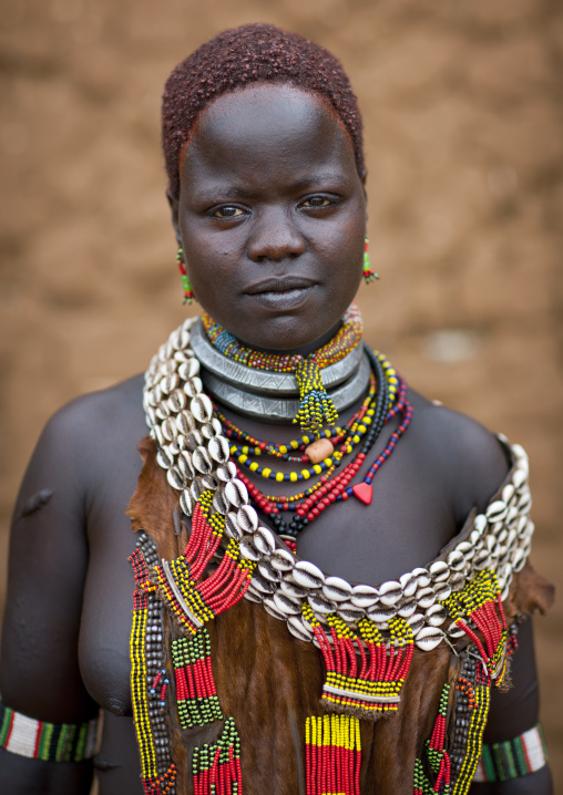Portrait Of Traditionally Dressed Hamer Beautiful Woman Posing In Front Of Clay House At Turmi Market Omo Valley Ethiopia