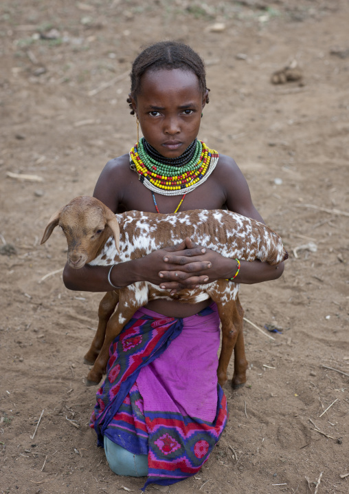 Young Dassanech Girl Looking Angry With Goat In Her Arms Omorate Ethiopia
