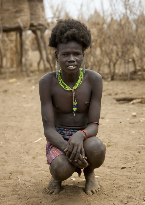 Hairy Squatting Dassanech Teenage Boy  Portrait Omorate Ethiopia