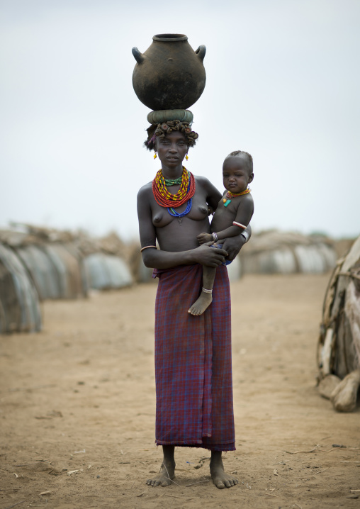 Portrait Of Dassanech Woman Topless Mother With Her Baby Carrying Clay Jar On Her Head Omorate Ethiopia