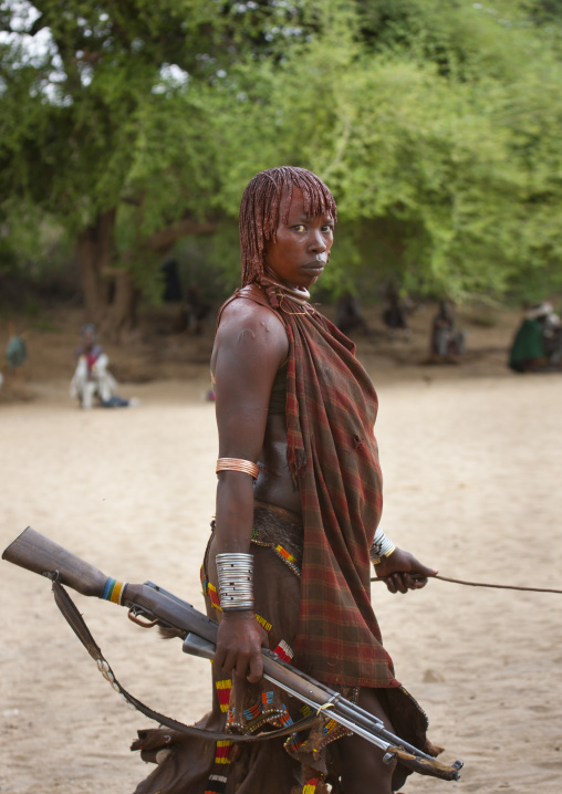 Hamer  Woman Walking With Kalashnikov Rifle In Hand Ethiopia