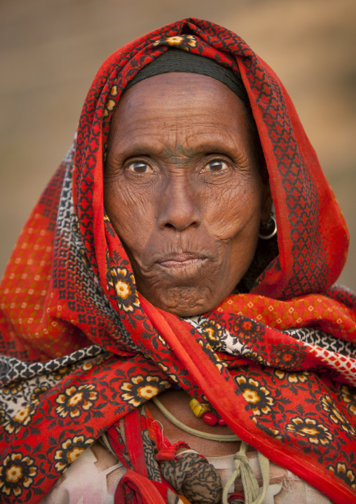 Portrait of a beautiful senior Ethiopian woman with orange scarf impressed by the camera, Dire dawa, Ethiopia