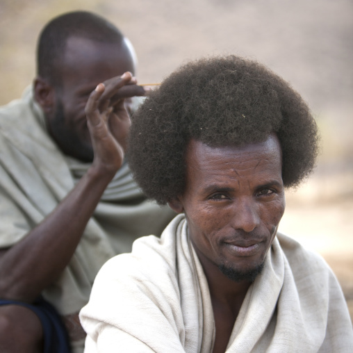 Smiling Karrayyu Tribe Man Having His Gunfura Traditional Hairstyle Done During Gadaaa Ceremony, Metehara, Ethiopia