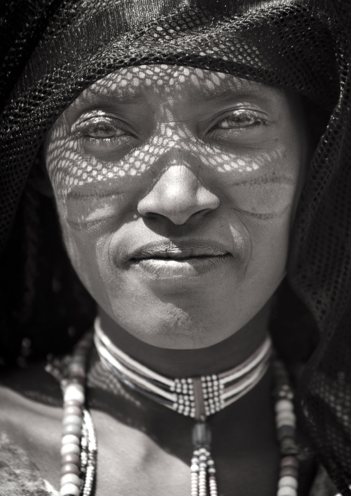 Black And White Portrait Of A Karrayyu Tribe Woman With Facial Scarifications, Black Headscarf And Jewels, Metahara, Ethiopia