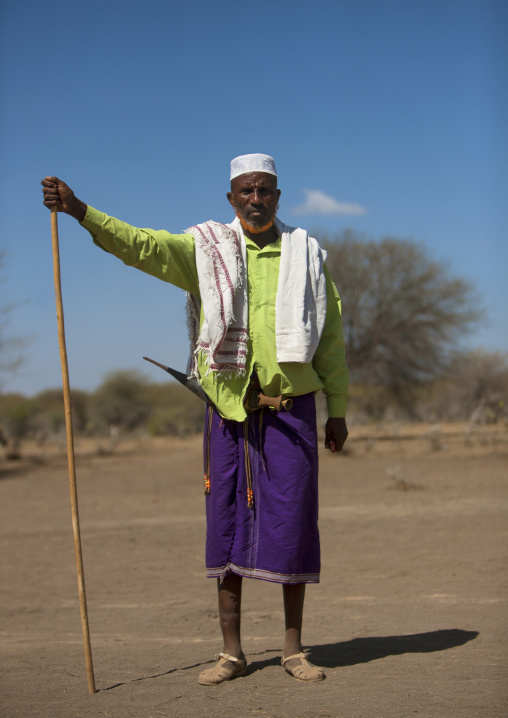 Portrait Of Karrayyu Tribe Elder With Ginger Tainted Beard, Mobile Phone And Long Stick During Gadaaa Ceremony, Metahara, Ethiopia