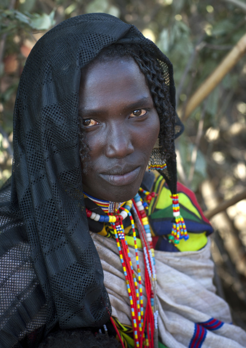 Portrait Of A Smiling Karrayyu Tribe Woman With Black Headscarf And Colourful Jewels During Gadaaa Ceremony In Metahara, Ethiopia