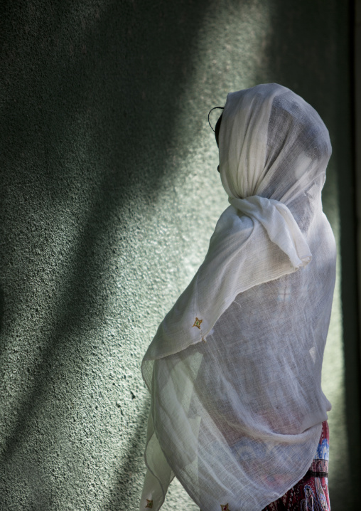 Rear view of a woman praying in front of the wall of a church, Zway, Ethiopia