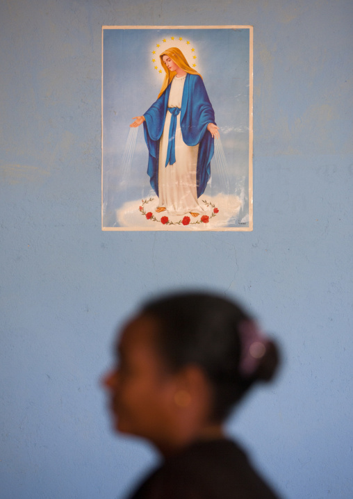 Woman praying below virgin maria poster in a church, Zway, Ehtiopia