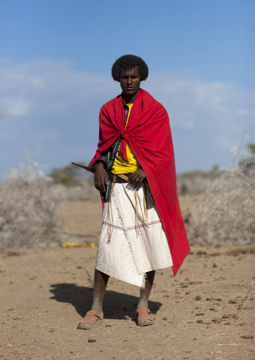Portrait Of A Karrayyu Tribe Man In Red Clothes With Traditional Gunfura Hairstyle During Gadaaa Ceremony, Metahara, Ethiopia