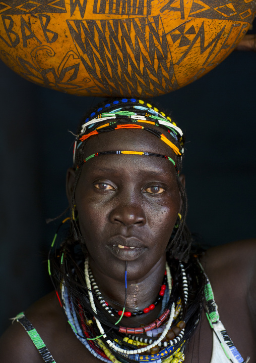 Woman With A Calabash On Her Head From Anuak Tribe In Traditional Clothing, Gambela, Ethiopia