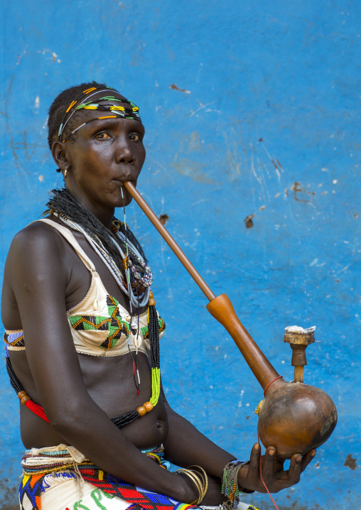 Woman Smoking A Waterpipe From Anuak Tribe In Traditional Clothing, Gambela, Ethiopia