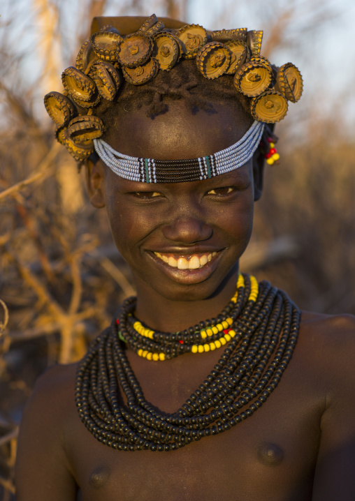 Portrait Of A Young Dassanech Girl Wearing Bottle Caps Headgear And Beaded Necklaces, Omorate, Omo Valley, Ethiopia