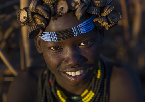 Portrait Of A Young Dassanech Girl Wearing Bottle Caps Headgear And Beaded Necklaces, Omorate, Omo Valley, Ethiopia