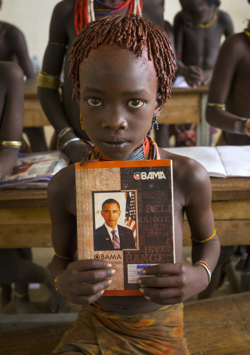 Hamer Tribe Girl Holding A Book With Barack Obama On The Cover In A School, Turmi, Omo Valley, Ethiopia