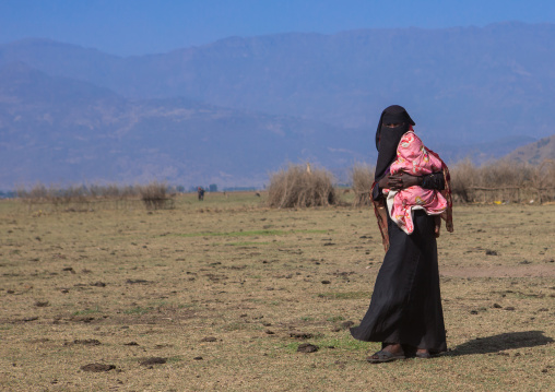 Ethiopian oromo mother with her baby dressed in burqa, Amhara region, Artuma, Ethiopia