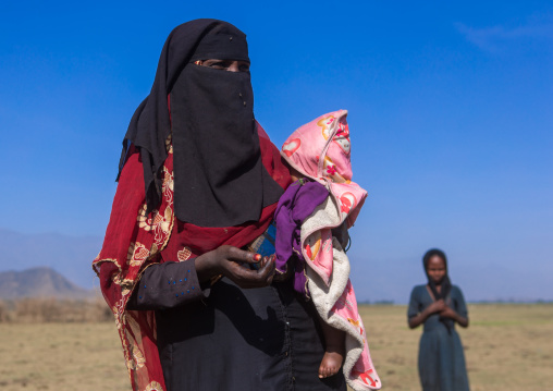 Ethiopian oromo mother with her baby dressed in burqa, Amhara region, Artuma, Ethiopia