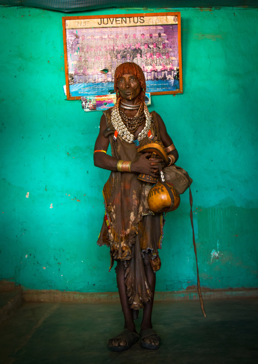 Hamer tribe woman standing in front of an old juventus poster, Omo valley, Turmi, Ethiopia