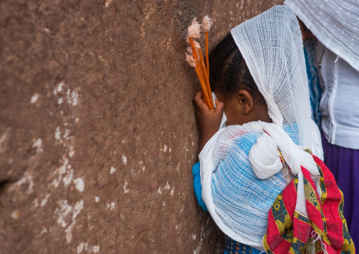 Pilgrim girl praying during kidane mehret orthodox celebration, Amhara region, Lalibela, Ethiopia