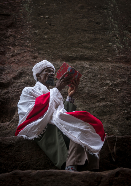 Orthodox priest praying with a bible, Amhara region, Lalibela, Ethiopia