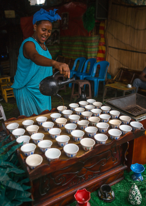 Ethiopian woman filled coffe cups in a bar, Semien wollo zone, Woldia, Ethiopia