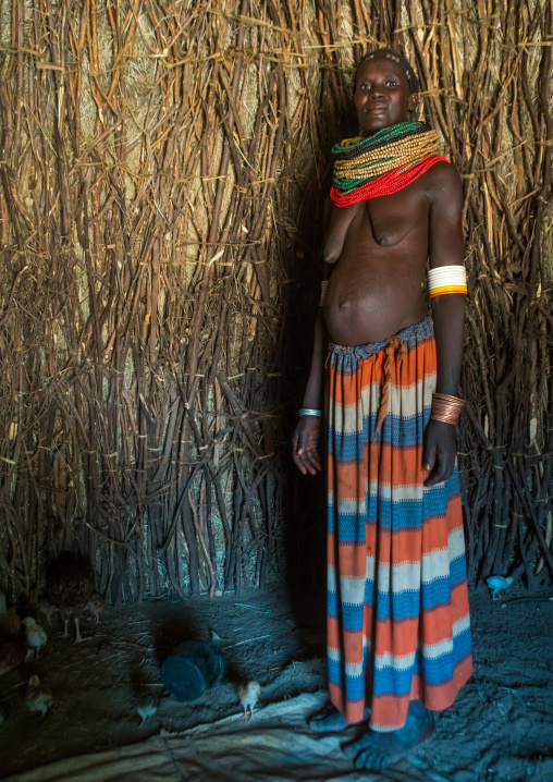 Toposa tribe woman standing in her hut, Omo valley, Kangate, Ethiopia