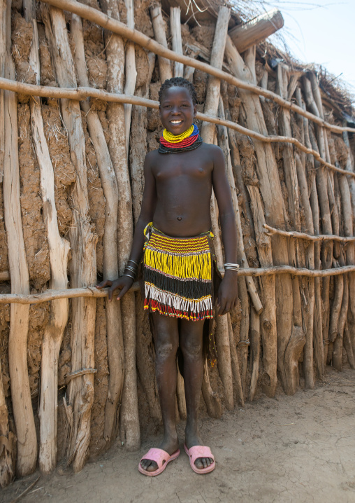 Portrait of a smiling nyangatom tribe girl with traditional beaded skirt, Omo valley, Kangate, Ethiopia