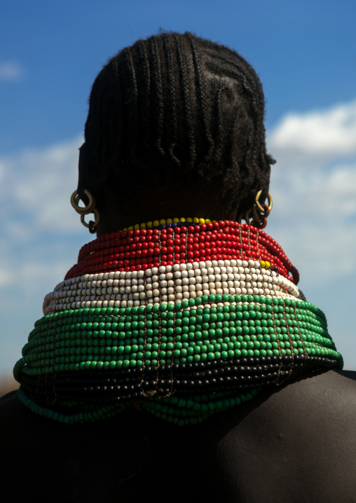 Rear view of a nyangatom tribe woman with piles of beads, Omo valley, Kangate, Ethiopia