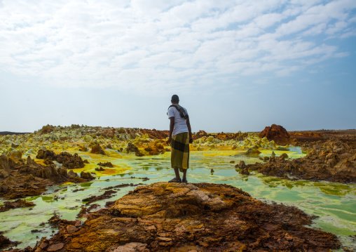 Afar man in front of colorful volcanic landscape in the danakil depression, Afar region, Dallol, Ethiopia