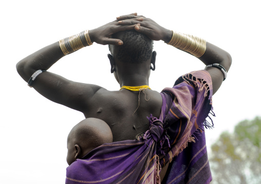 Mursi tribe woman carrying her baby in her back, Omo valley, Mago park, Ethiopia