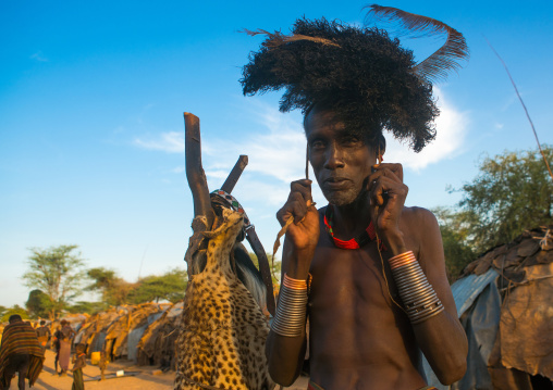 Dassanech man dressing with a ostrich feathers headwear for dimi ceremony to celebrate circumcision of the teenagers, Omo valley, Omorate, Ethiopia