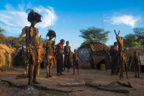 Dassanech men put on leopard skins and ostrich feathers headdresses to join dimi ceremony to celebrate circumcision of teenagers, Omo valley, Omorate, Ethiopia