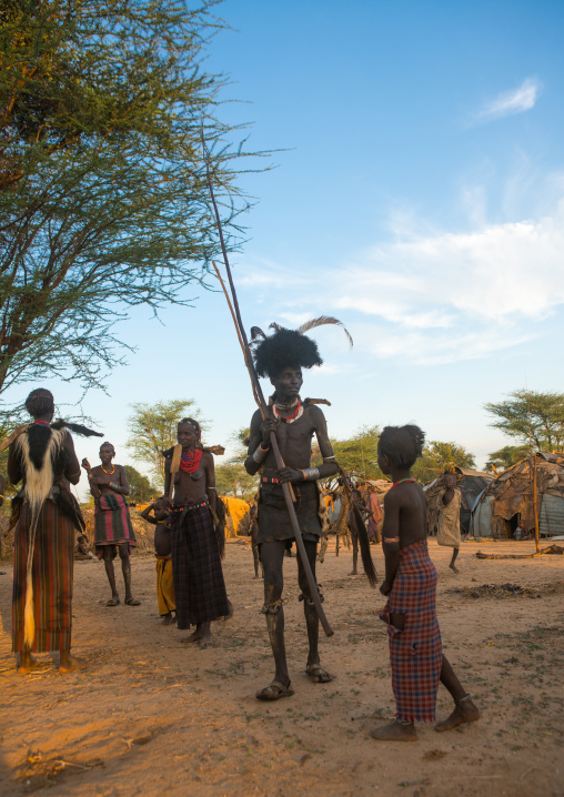 Dassanech men put on leopard skins and ostrich feathers headdresses to join dimi ceremony to celebrate circumcision of teenagers, Omo valley, Omorate, Ethiopia