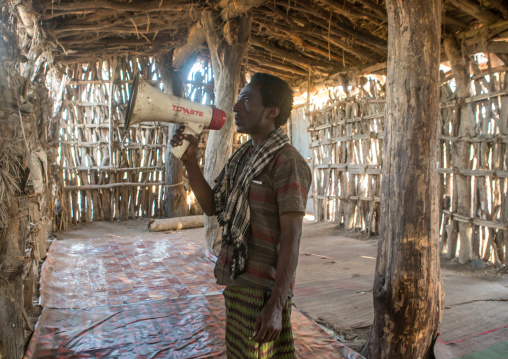 Afat tribe imam inside a wooden mosque calling will a megaphone, Afar region, Afambo, Ethiopia