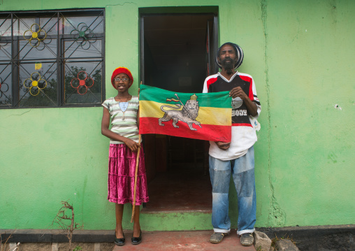 Rastafari girl called kizzy holding a flag with her father, Oromo, Shashamane, Ethiopia