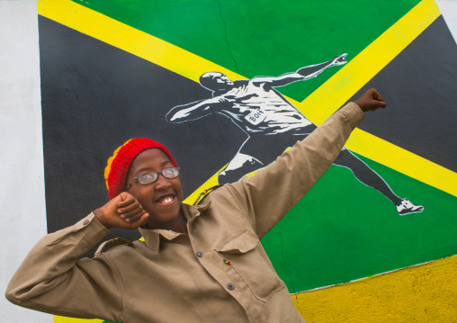 Rastafari girl called kizzy in front of a jamaica flag with hussein bolt mural, Oromo, Shashamane, Ethiopia