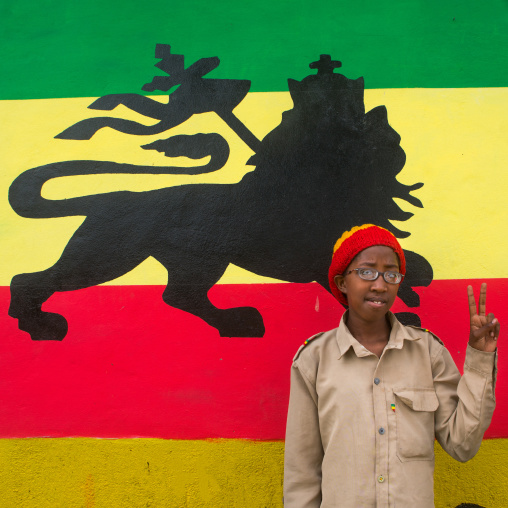 Rastafari girl called kizzy in front of a lion of judah mural, Oromo, Shashamane, Ethiopia