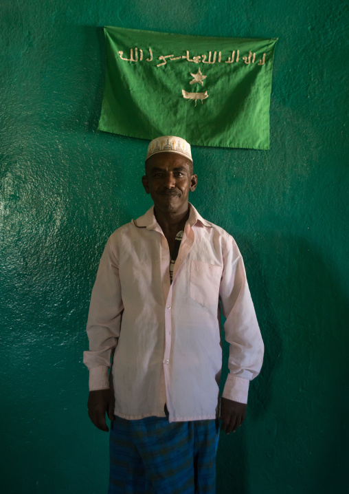 Sufi imam in front of islamic green flag, Harari region, Harar, Ethiopia