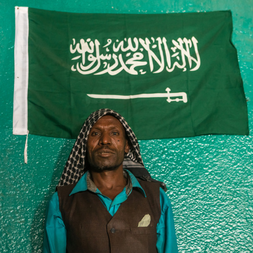 Sufi imam in front of islamic green flag, Harari region, Harar, Ethiopia