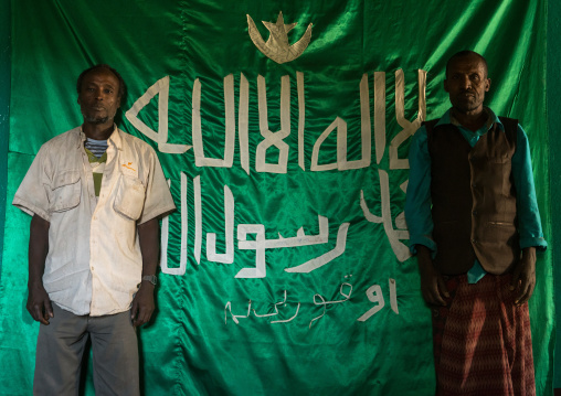 Sufi men worshippers in front of islamic flag, Harari region, Harar, Ethiopia